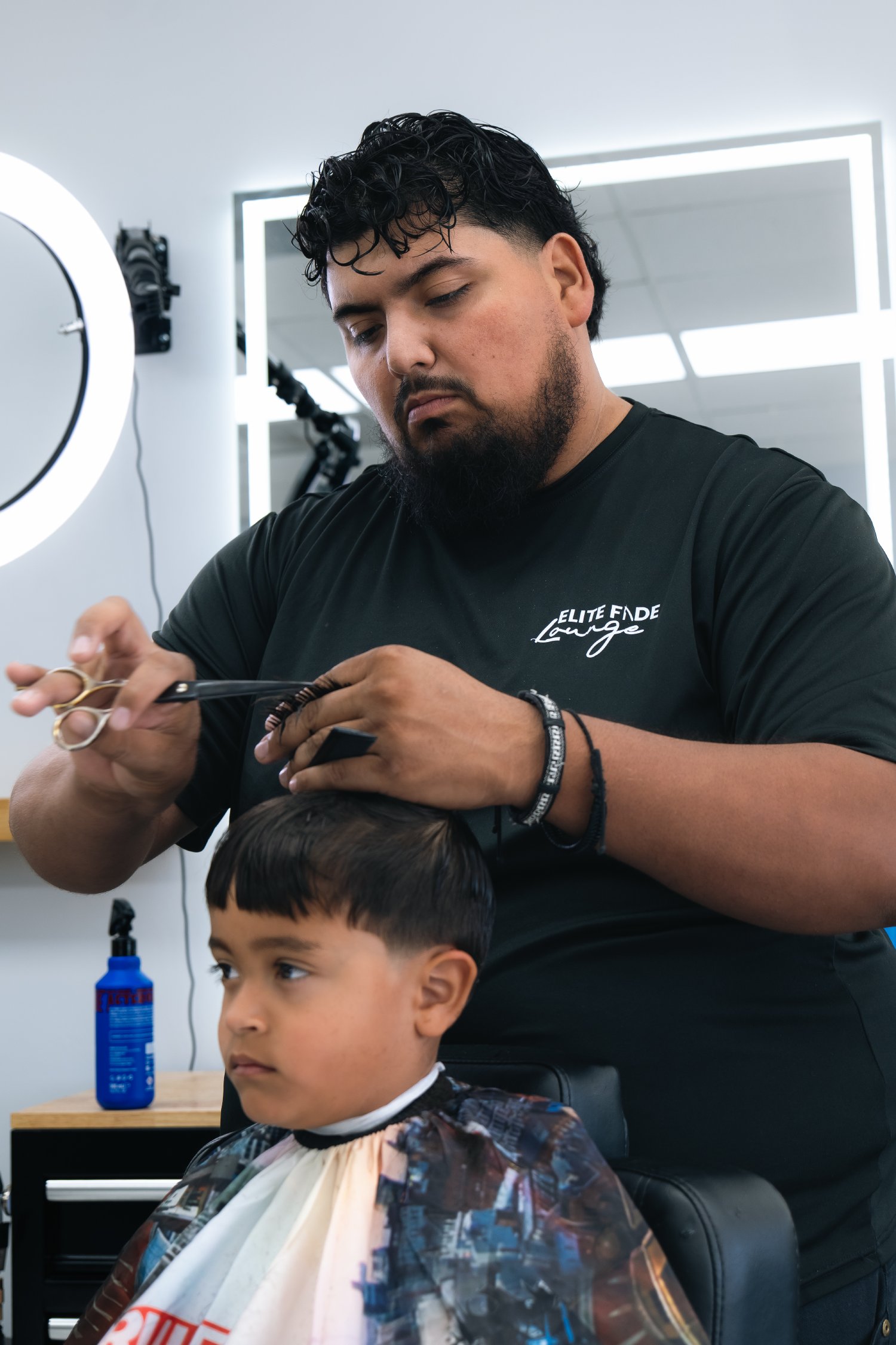 Barber giving a kid's haircut at Elite Fade Lounge
