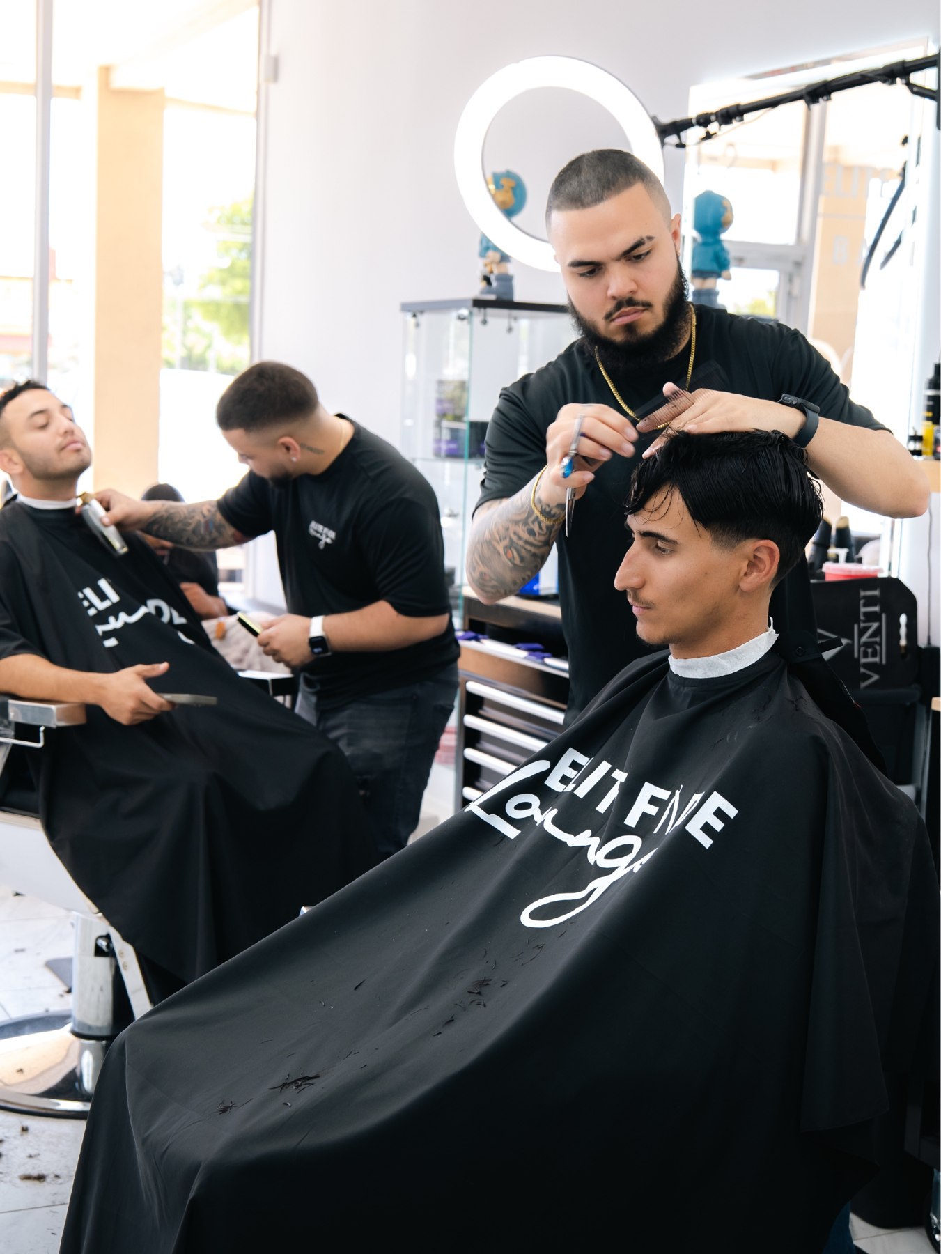 Wide view of the Elite Fade Lounge barbershop team at work