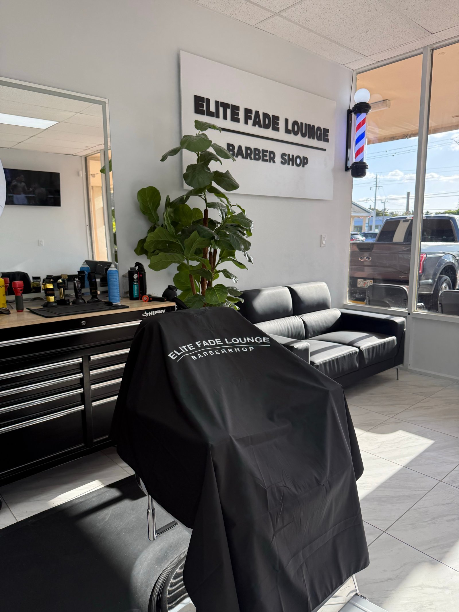 Barber lining up a client's fade at Elite Fade Lounge